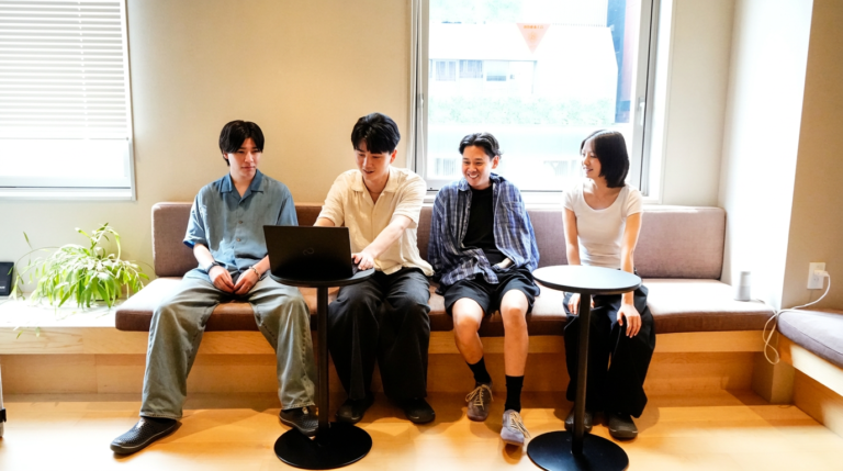 ソファ席でノートPCを囲んで話すメンバー